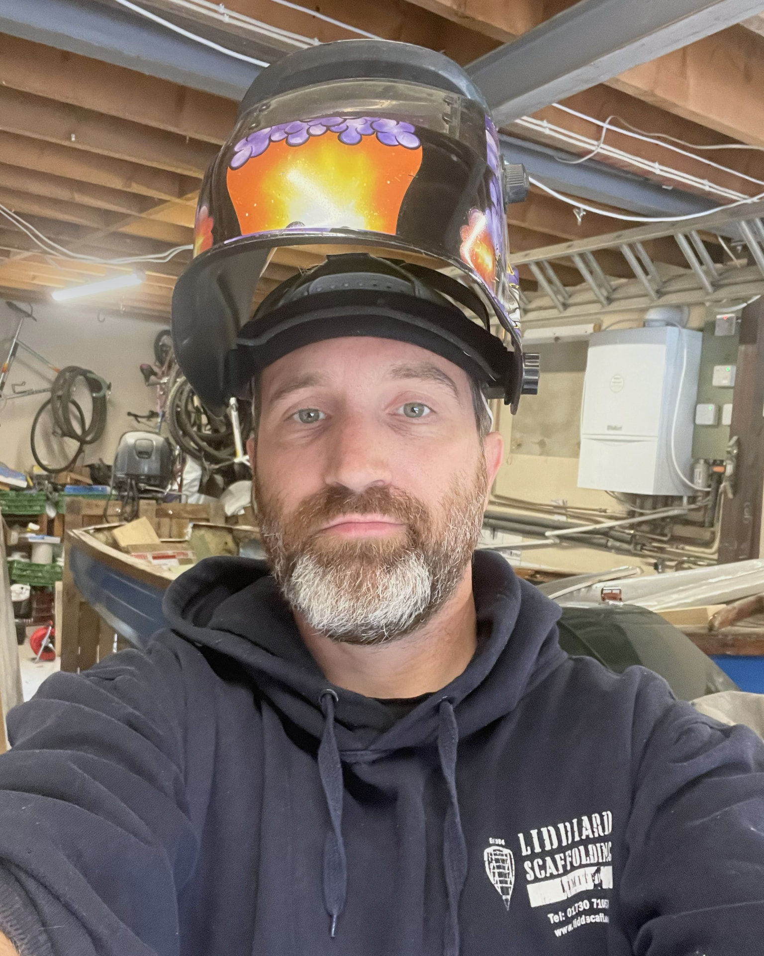 Jonathan in his workshop, welding helmet up